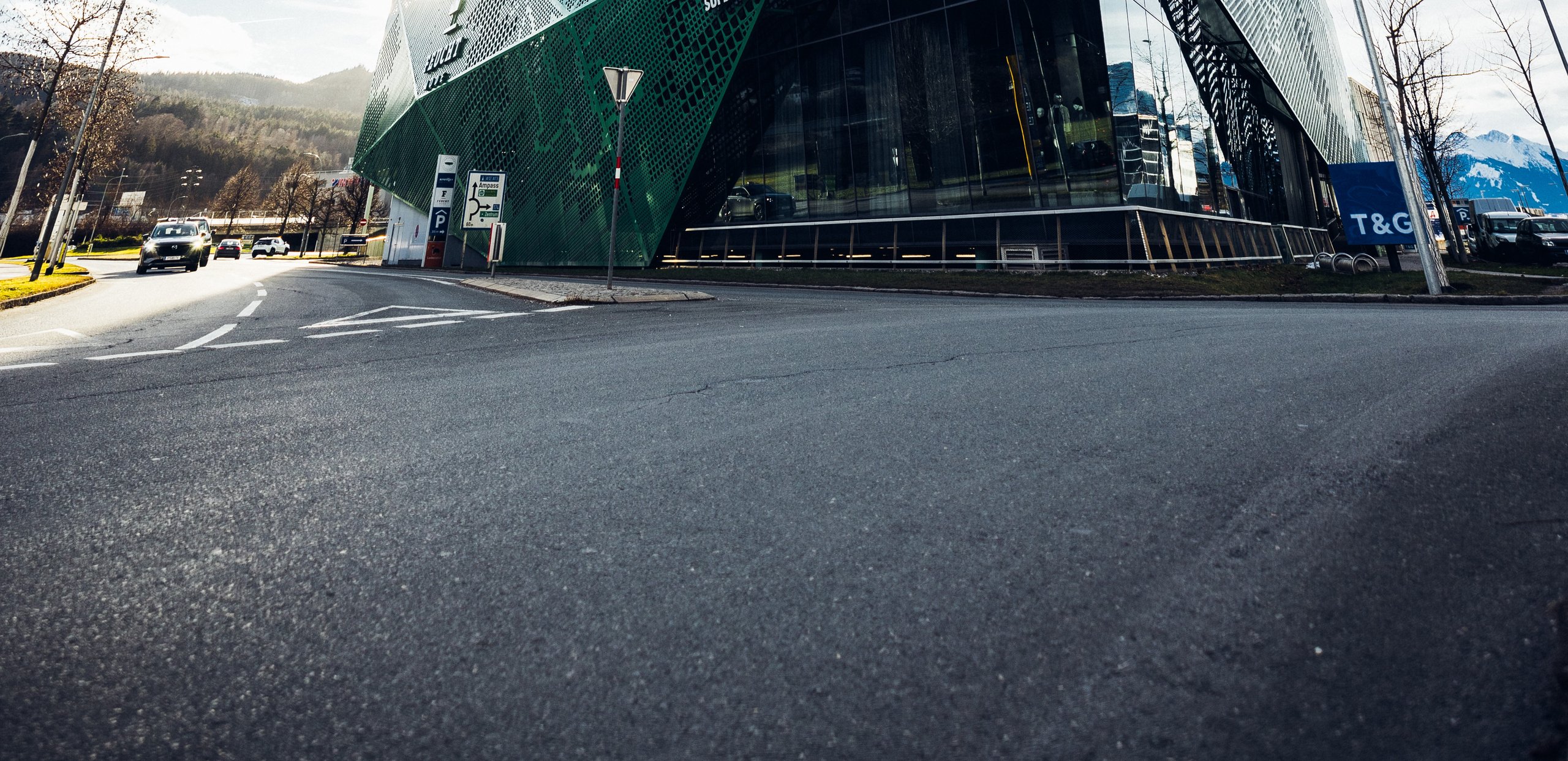 Straße in der Rossau mit dem Gebäude von Mode von Feucht im Hintergrund. Fokus liegt auf der Straße