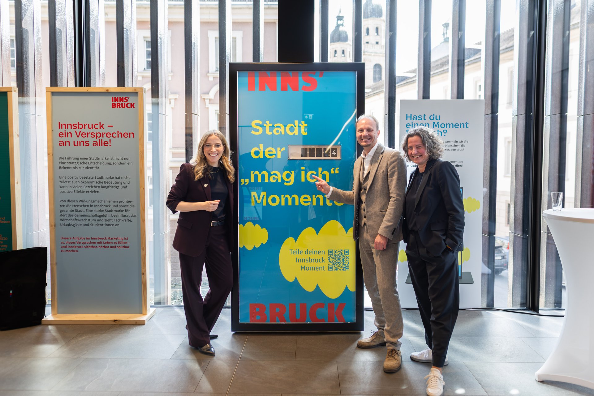 Bürgermeister Johannes Anzengruber, Heike Kiesling und Barbara Plattner vor der "Innsbruck Momente" Stele mit Faltblattzähler.